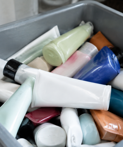 Flacons tubes cosmetiques empiles dans conteneur gris