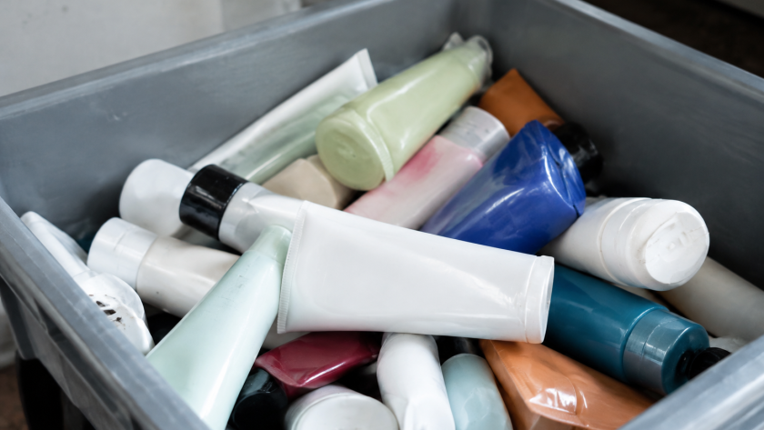 Flacons tubes cosmetiques empiles dans conteneur gris