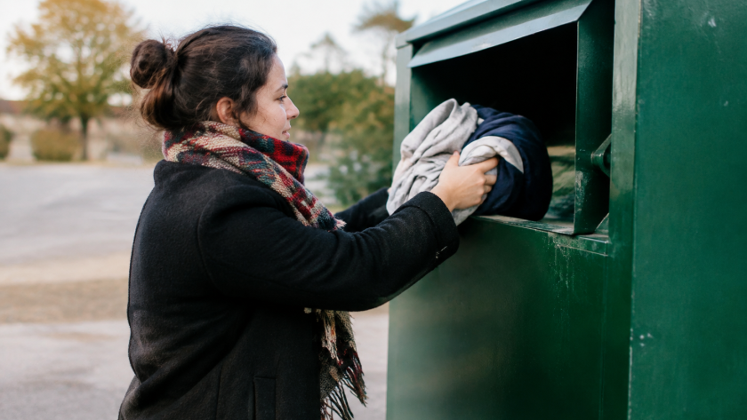 Main deposant vetement dans bac de collecte