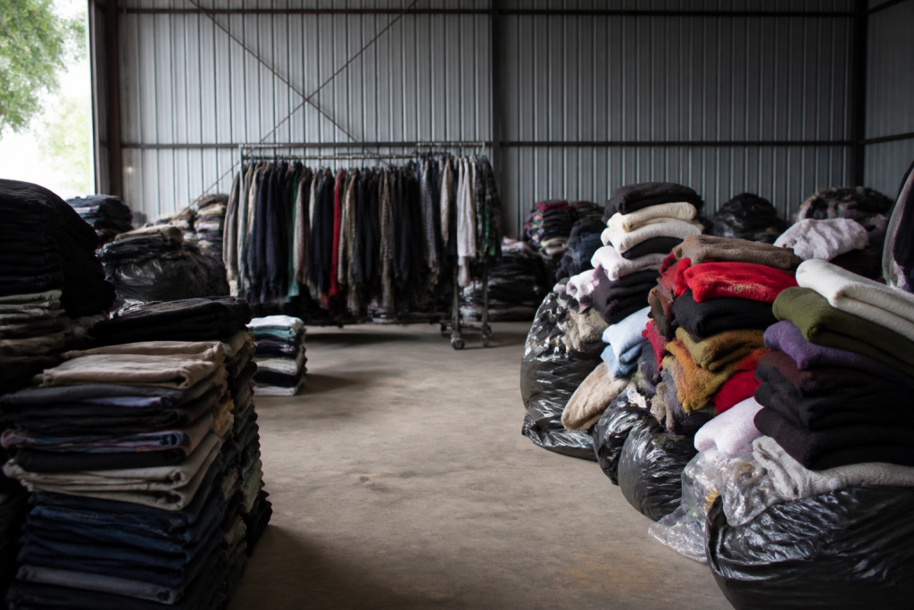 Vetements disposes par categories visibles dans hangar